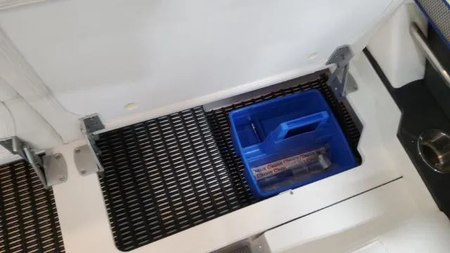 Slide: The Image of Storage compartment of a 2022 Formula 380 Super Sport Crossover boat with a blue toolbox. - 46