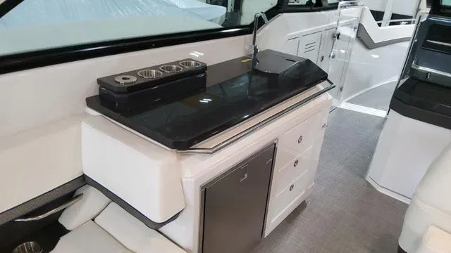 Slide: The Image of 2022 Formula 380 Super Sport Crossover interior with kitchenette and seating area. - 49