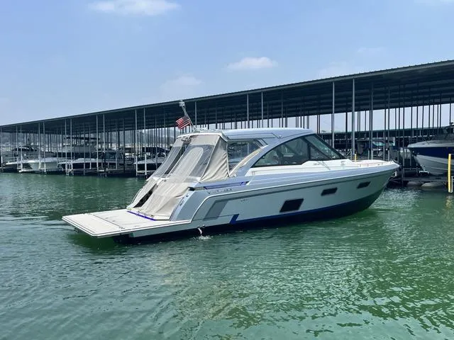 Slide: The Image of 2022 Formula 380 Super Sport Crossover boat docked in marina. - 7
