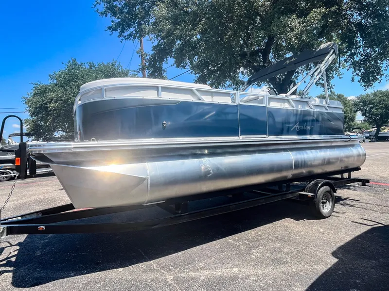 The Image of 2024 Avalon VLS 21 Quad Lounger pontoon boat on trailer, parked outdoors. - 0