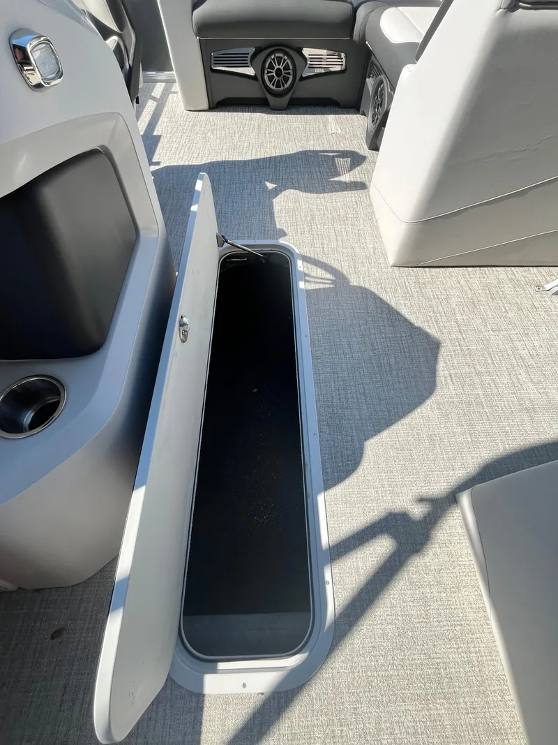 Slide: The Image of 2024 Avalon LSZ Versatile Rear Bench with open storage compartment on boat deck. - 16