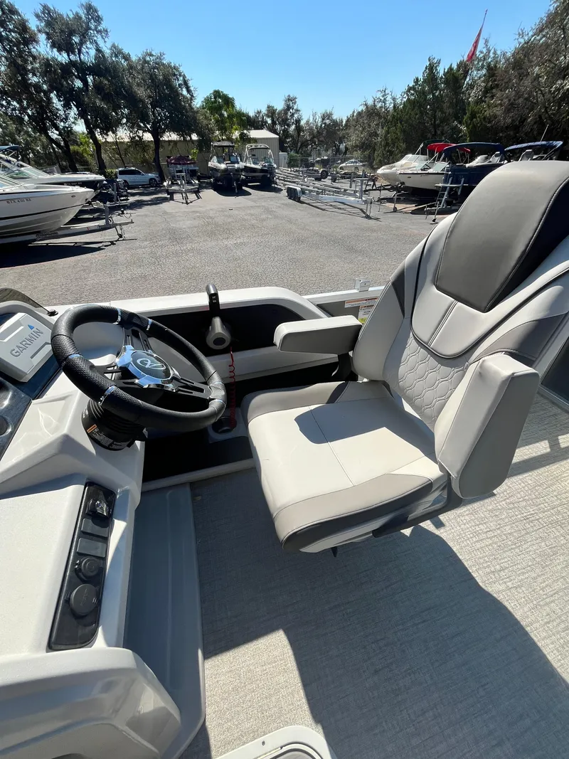 Slide: The Image of 2024 Avalon LSZ Versatile Rear Bench boat interior with steering wheel and captain's chair. - 2