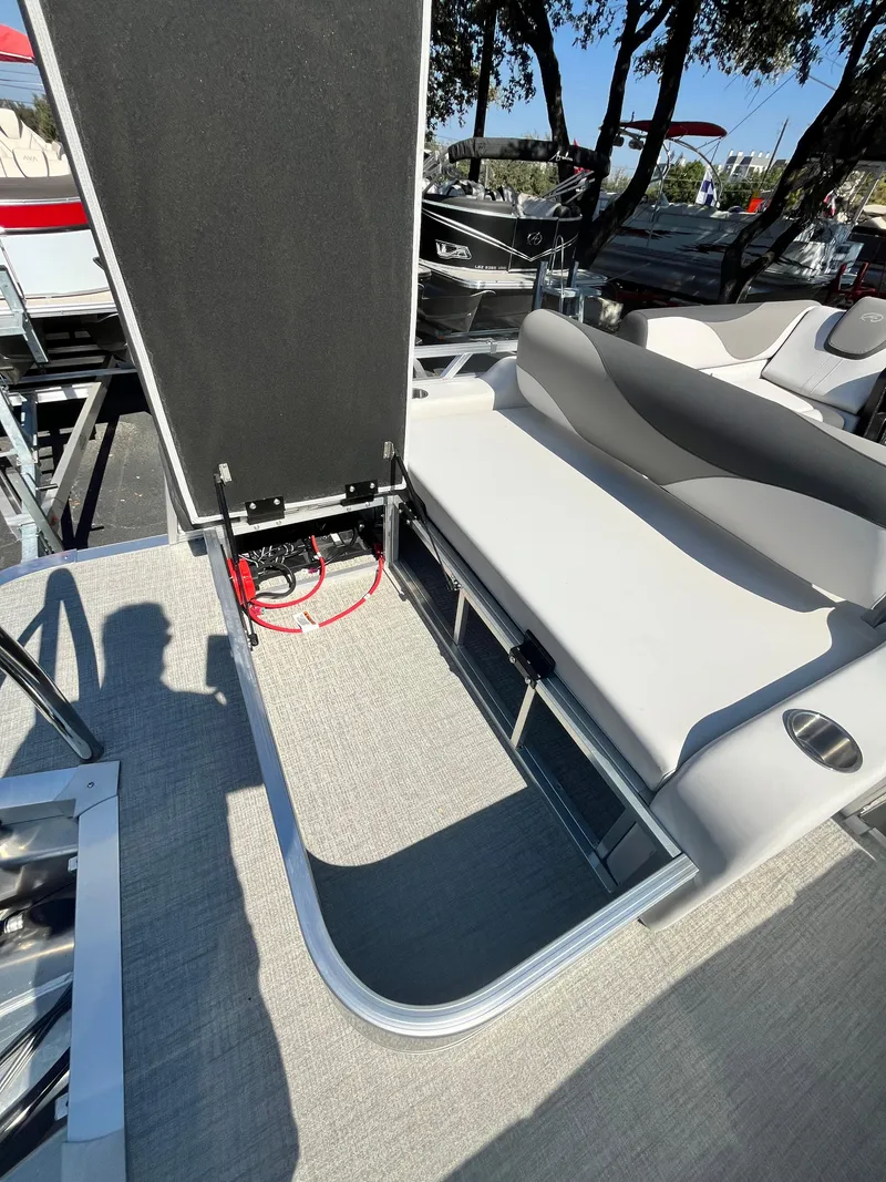 Slide: The Image of 2024 Avalon LSZ Versatile Rear Bench with open storage compartment on a boat deck. - 7
