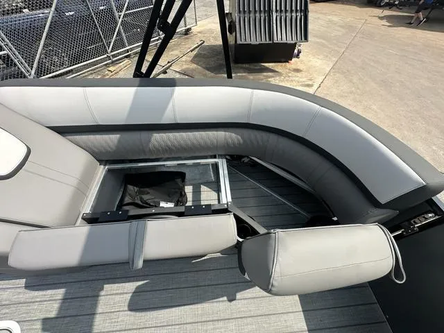 Slide: The Image of 2024 Avalon Catalina 25' Quad Lounger boat interior with gray seating and storage compartment. - 37