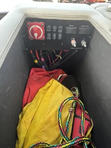 Slide: The Image of 2015 Bennington 25 IO QCW boat storage compartment with control panel and colorful ropes. - 7