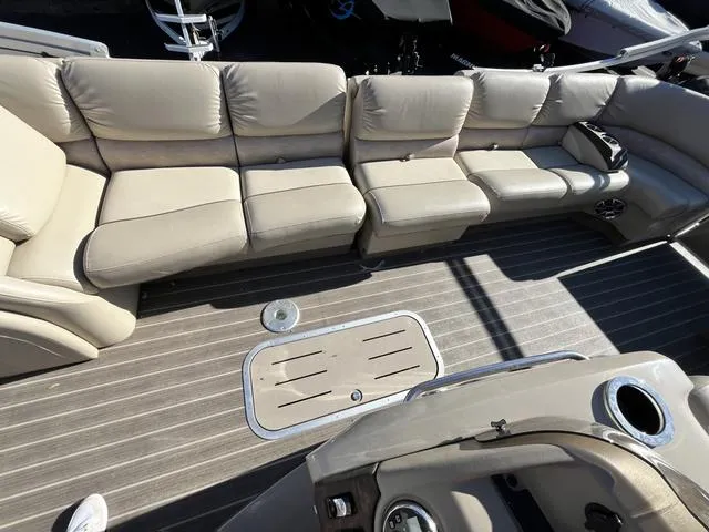 Slide: The Image of 2015 Bennington 2275 RCW boat interior with beige leather seating and gray flooring. - 12