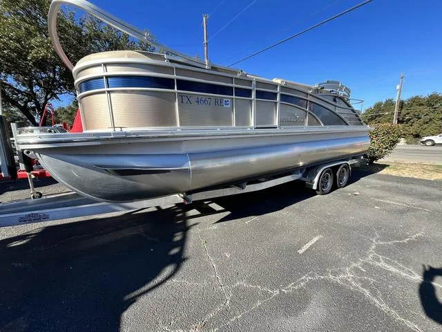 Slide: The Image of 2015 Bennington 2275 RCW pontoon boat on a trailer in a parking lot. - 2