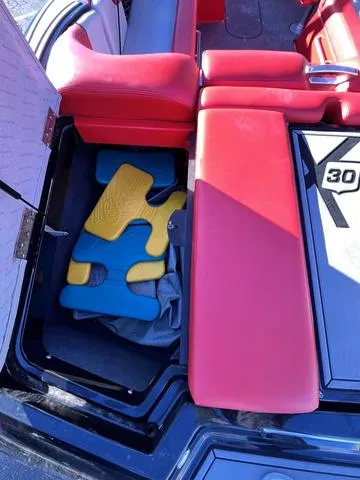 Slide: The Image of 2016 MasterCraft X30 boat with red seating and storage compartment. - 10