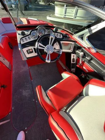 Slide: The Image of 2016 MasterCraft X30 boat interior with red and white seating, modern dashboard, and steering wheel. - 12