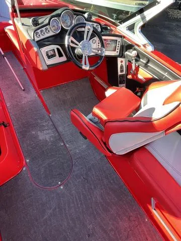 Slide: The Image of 2016 MasterCraft X30 boat interior with red and white seating and modern dashboard. - 13