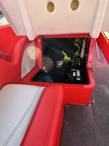Slide: The Image of 2016 MasterCraft X30 boat interior storage compartment with red and white seating. - 17