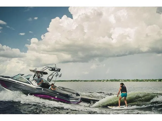 Slide: The Image of 2016 MasterCraft X30 boat towing a wakeboarder on a lake under cloudy skies. - 23