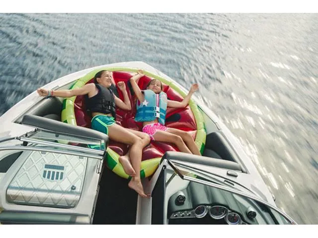 Slide: The Image of Two people relaxing on a 2016 MasterCraft X30 boat with an inflatable float. - 24