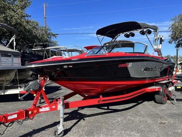 Slide: The Image of 2016 MasterCraft X30 boat on a red trailer in a parking lot. - 3