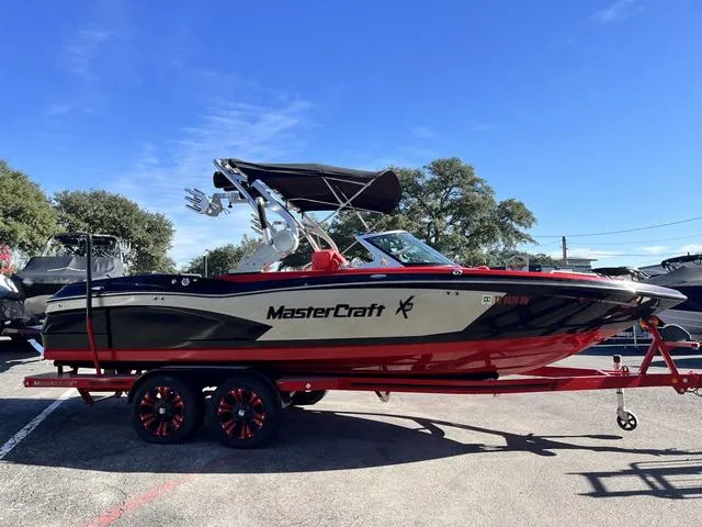 Slide: The Image of 2016 MasterCraft X30 boat with red and black design on a trailer. - 4