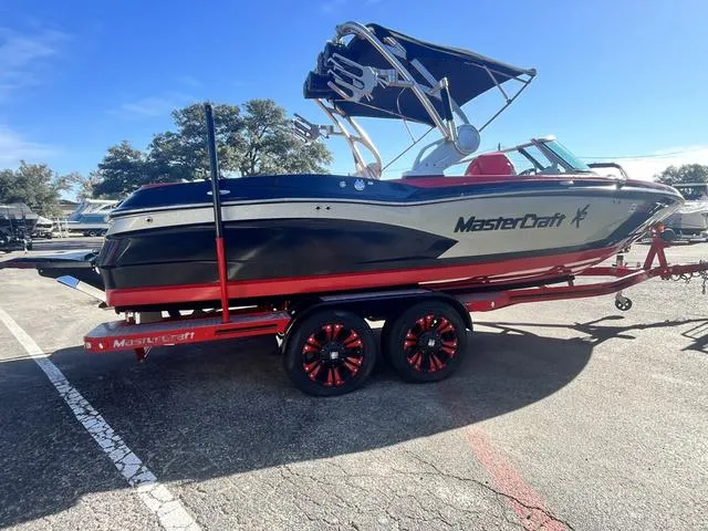 Slide: The Image of 2016 MasterCraft X30 boat on a red trailer in a parking lot. - 6