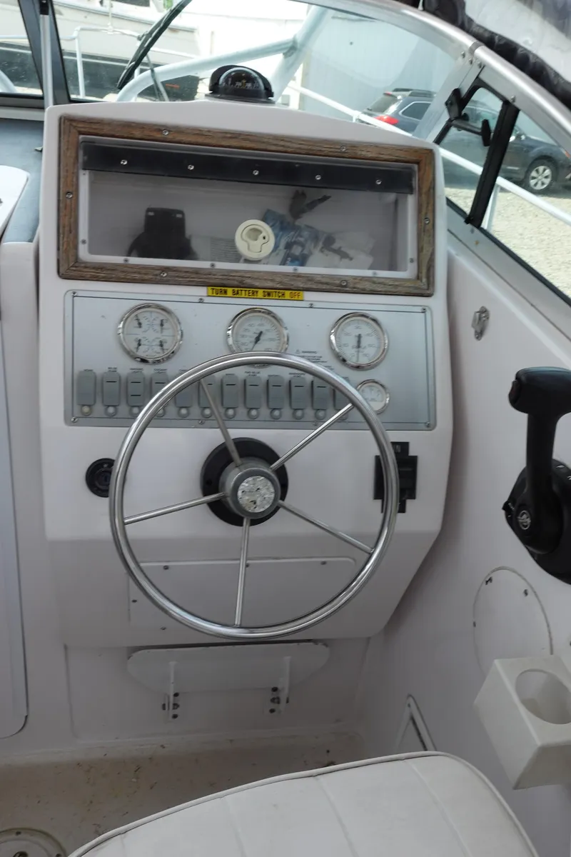 Slide: The Image of 2000 Pro-Line 24 Walk boat dashboard with steering wheel and gauges. - 9