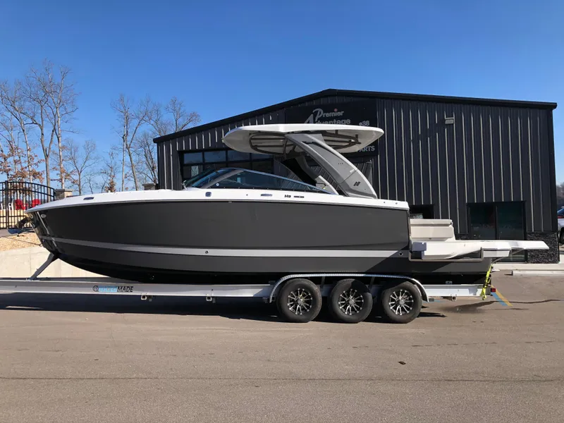 Slide: The Image of 2025 Four Winns H9 boat on trailer, parked outside a building. - 24