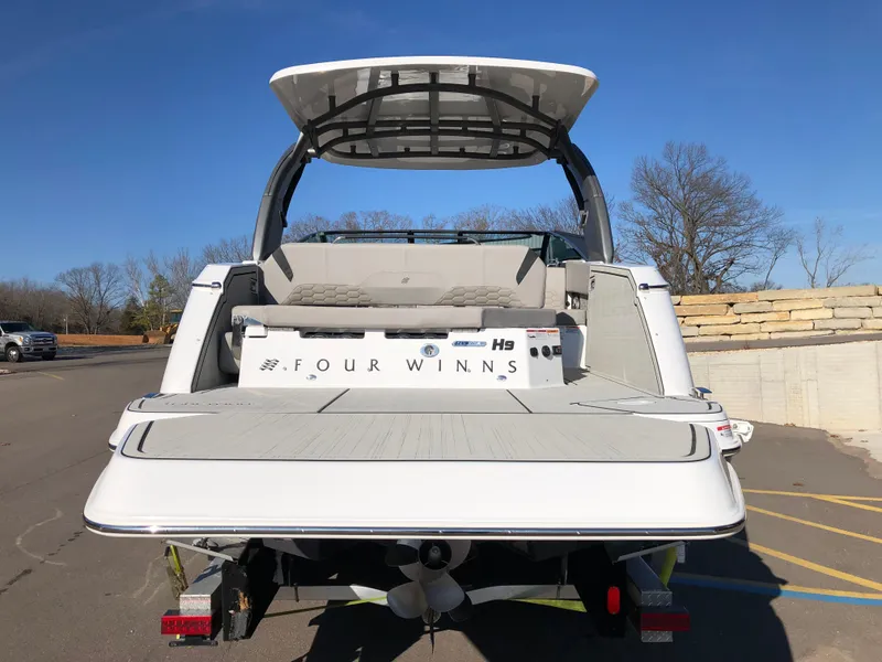 Slide: The Image of 2025 Four Winns H9 boat, rear view, on trailer, sunny day. - 9