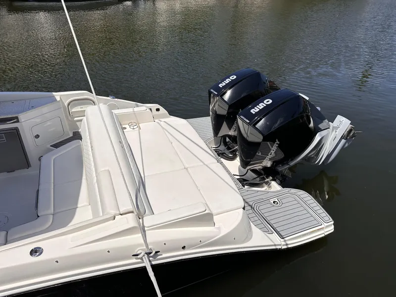 Slide: The Image of 2021 Sea Ray SDX 290 Outboard with twin engines docked on calm water. - 16