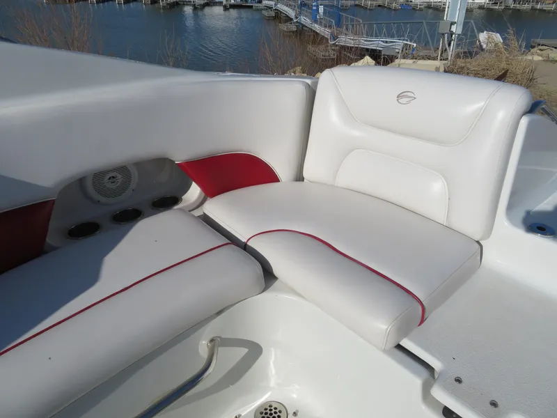Slide: The Image of 2012 Crownline 275 SS boat with white and red seating near a marina. - 10