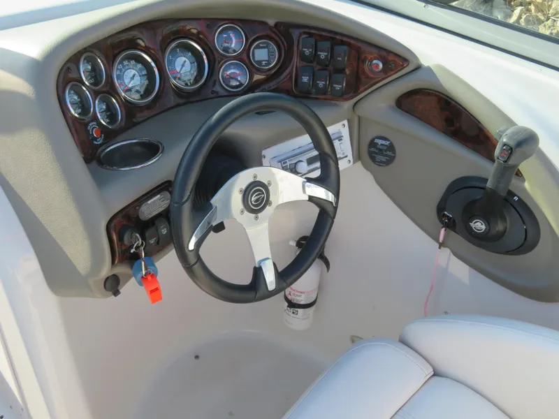 Slide: The Image of 2012 Crownline 275 SS boat dashboard with steering wheel and control panel. - 13