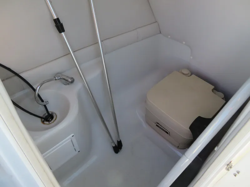 Slide: The Image of 2012 Crownline 275 SS boat interior bathroom with sink and portable toilet. - 23