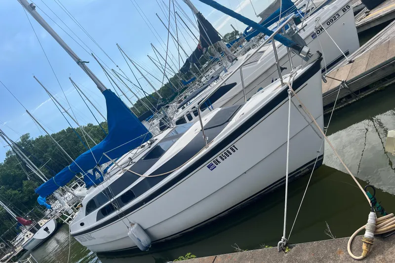 Slide: The Image of 2010 MacGregor 26M sailboat docked at a marina. - 1