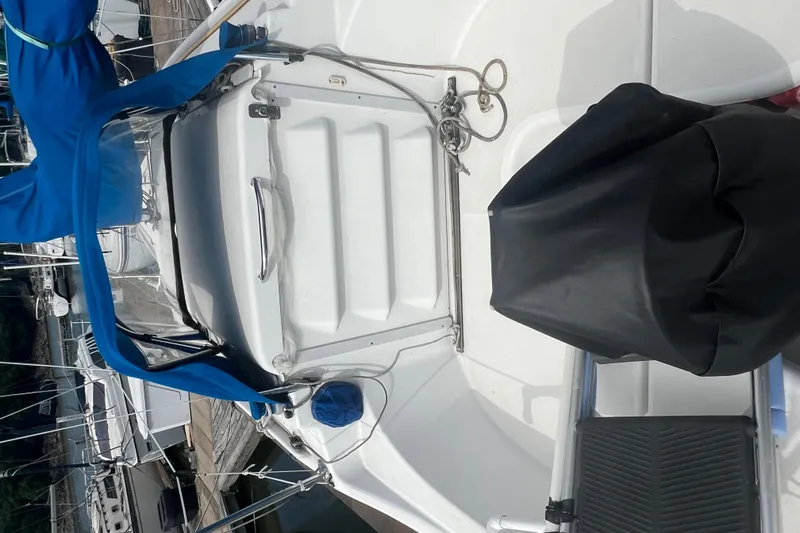 Slide: The Image of 2010 MacGregor 26M sailboat with blue canopy docked at marina. - 12