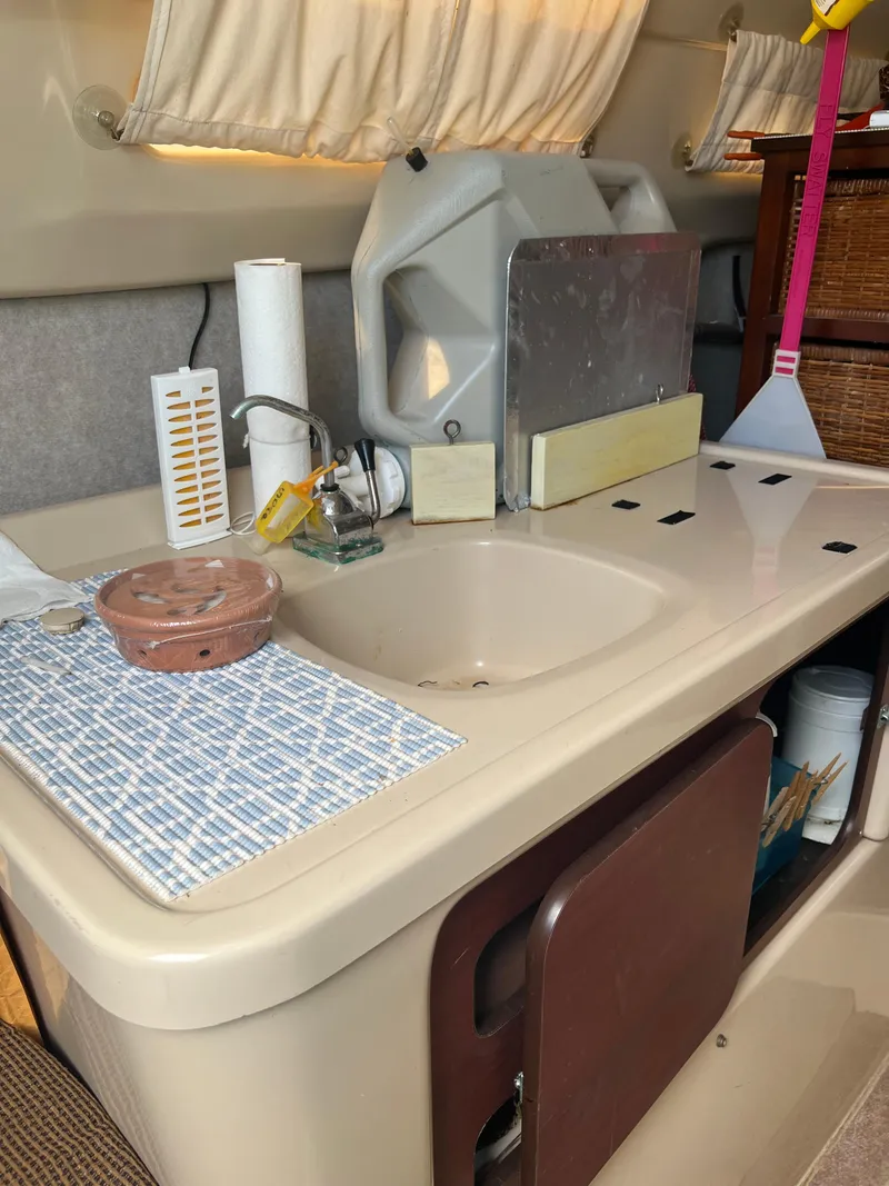 Slide: The Image of 2010 MacGregor 26M boat interior kitchen sink area with accessories. - 2