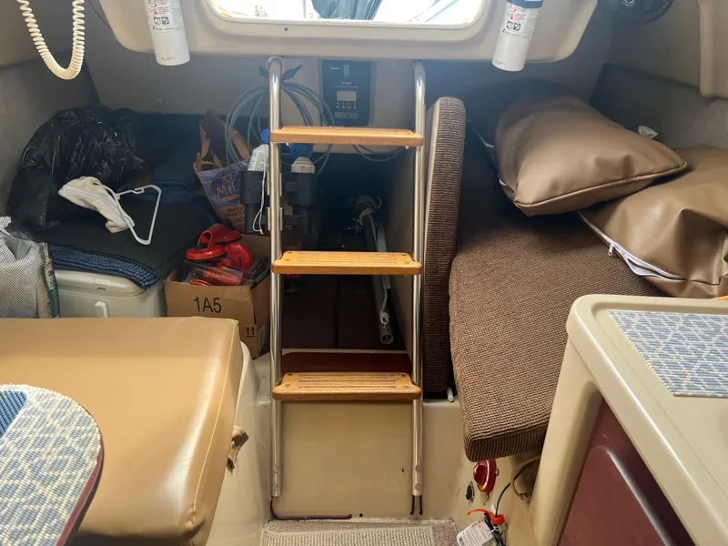 Slide: The Image of Interior of a 2010 MacGregor 26M sailboat with wooden steps and seating area. - 3