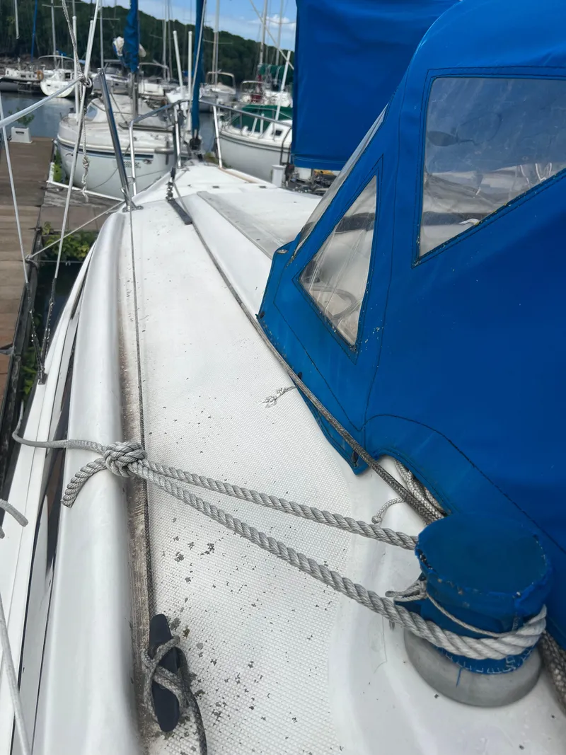 Slide: The Image of 2010 MacGregor 26M sailboat docked at marina with blue canopy. - 9