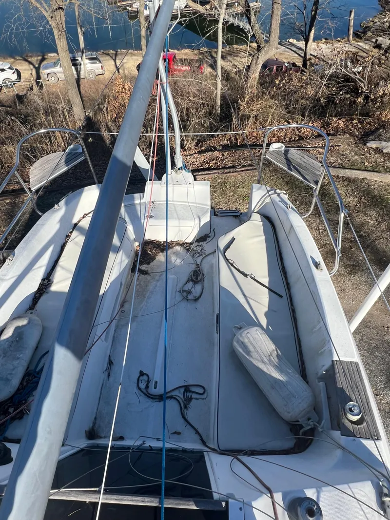 Slide: The Image of 2002 Hunter 240 sailboat deck with rigging and seating, docked near a lake. - 12