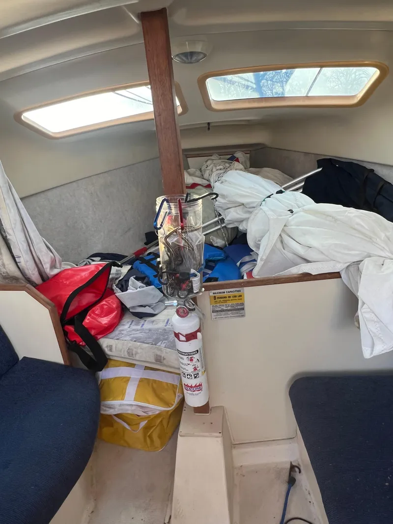 Slide: The Image of Interior of a 2002 Hunter 240 sailboat with cluttered cabin and fire extinguisher. - 4
