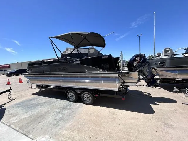 Slide: The Image of 2024 Avalon Catalina Rear Fish 23 FT pontoon boat on a trailer under a clear blue sky. - 7