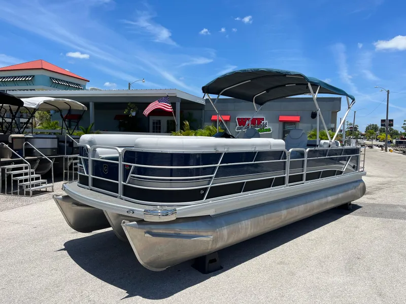 The Image of 2022 Godfrey SWEETWATER 2486 SFL pontoon boat with canopy, docked outdoors. - 0