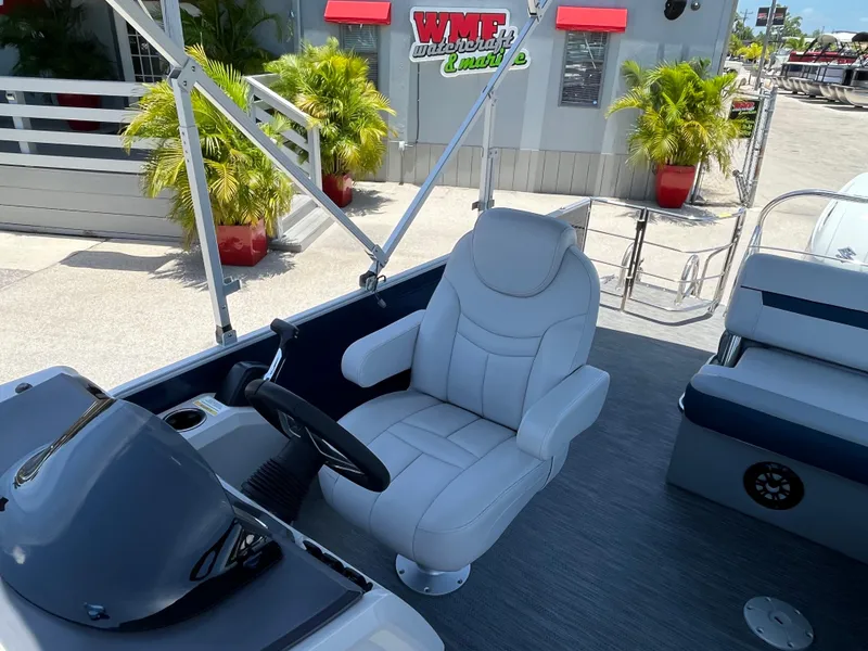 Slide: The Image of 2022 Godfrey SWEETWATER 2486 SFL boat interior with captain's chair and steering console. - 16