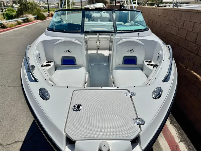 Slide: The Image of 2016 Monterey 244FS boat interior with seating and storage, parked on a sunny day. - 11