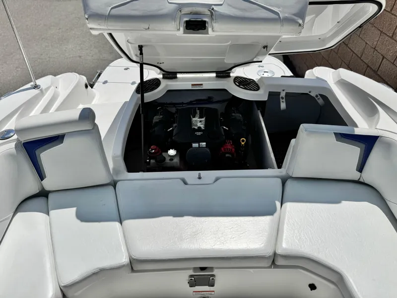 Slide: The Image of 2016 Monterey 244FS boat engine compartment with open hatch and white seating. - 22