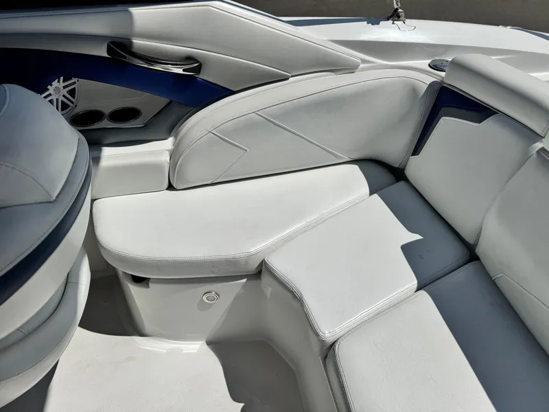 Slide: The Image of 2016 Monterey 244FS boat interior with white cushioned seating and blue accents. - 25