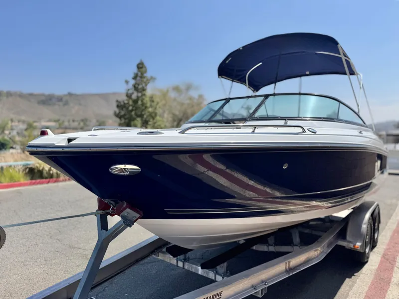 Slide: The Image of 2016 Monterey 244FS boat on trailer, blue hull, parked outdoors under clear sky. - 3