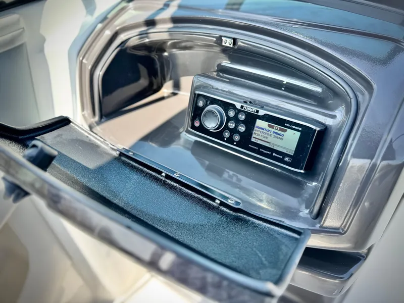 Slide: The Image of 2016 Monterey 244FS boat stereo system with open compartment, featuring Fusion marine radio. - 30