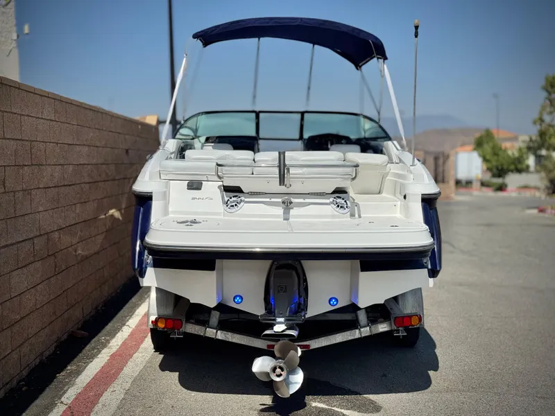 Slide: The Image of 2016 Monterey 244FS boat, rear view, parked on a street with a blue canopy. - 4