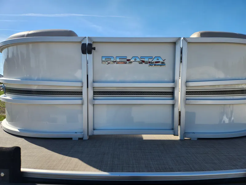 Slide: The Image of 2018 Ranger Reata 220C pontoon boat rear view under clear blue sky. - 11