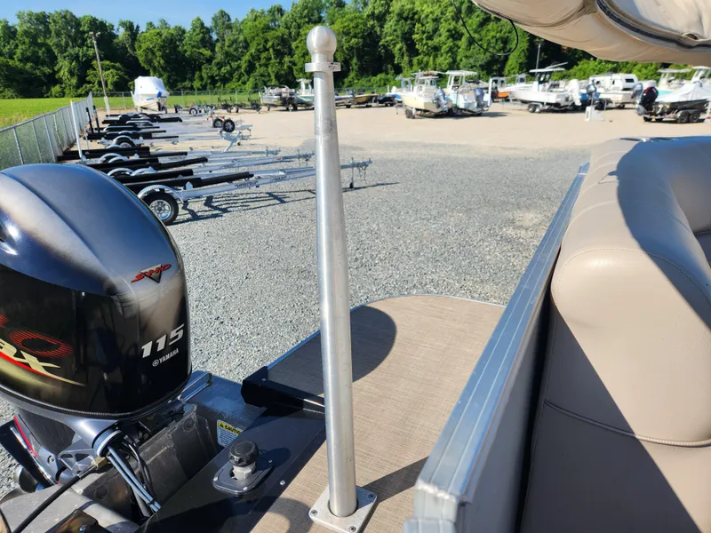 Slide: The Image of 2018 Ranger Reata 220C pontoon boat with 115 horsepower outboard motor in a boatyard. - 12