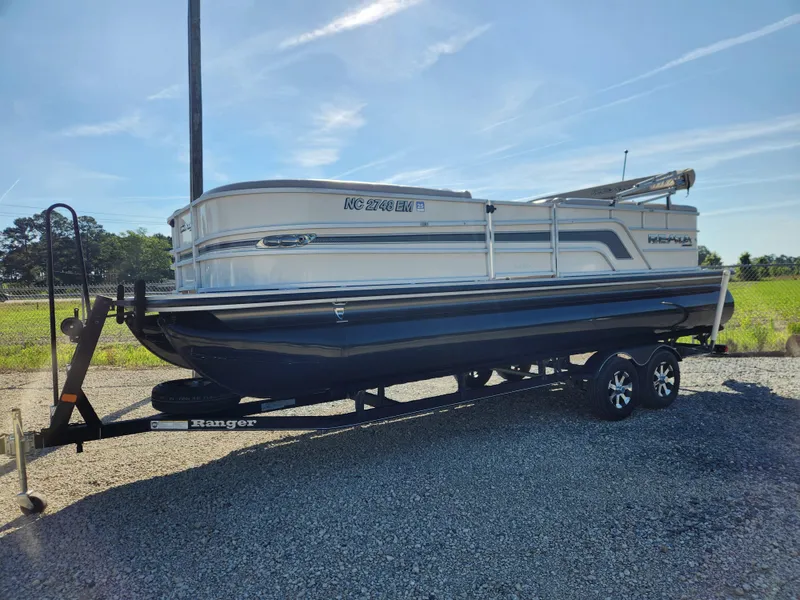 Slide: The Image of 2018 Ranger Reata 220C pontoon boat on trailer in outdoor setting. - 4