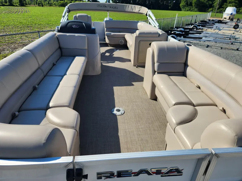 Slide: The Image of 2018 Ranger Reata 220C pontoon boat with spacious seating and beige upholstery. - 9