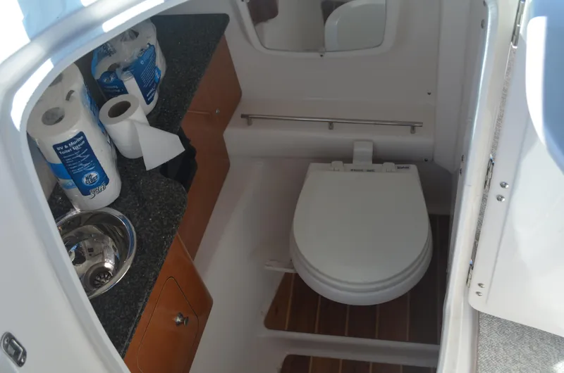 Slide: The Image of 2008 Chaparral 284 Sunesta boat bathroom with toilet, sink, and storage. - 10