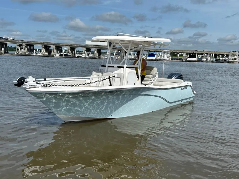 Slide: The Image of 2022 Sea Fox 249 Avenger boat on calm water near a marina. - 2