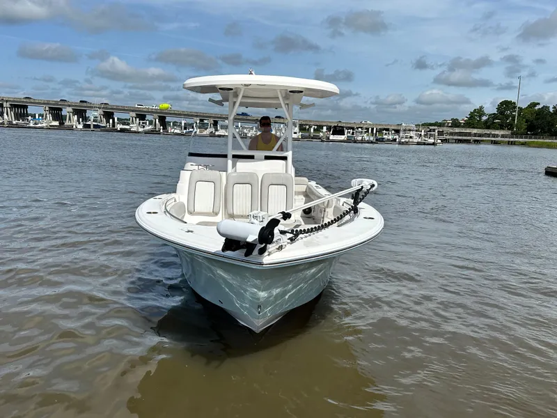 Slide: The Image of 2022 Sea Fox 249 Avenger boat on water near marina with bridge in background. - 4
